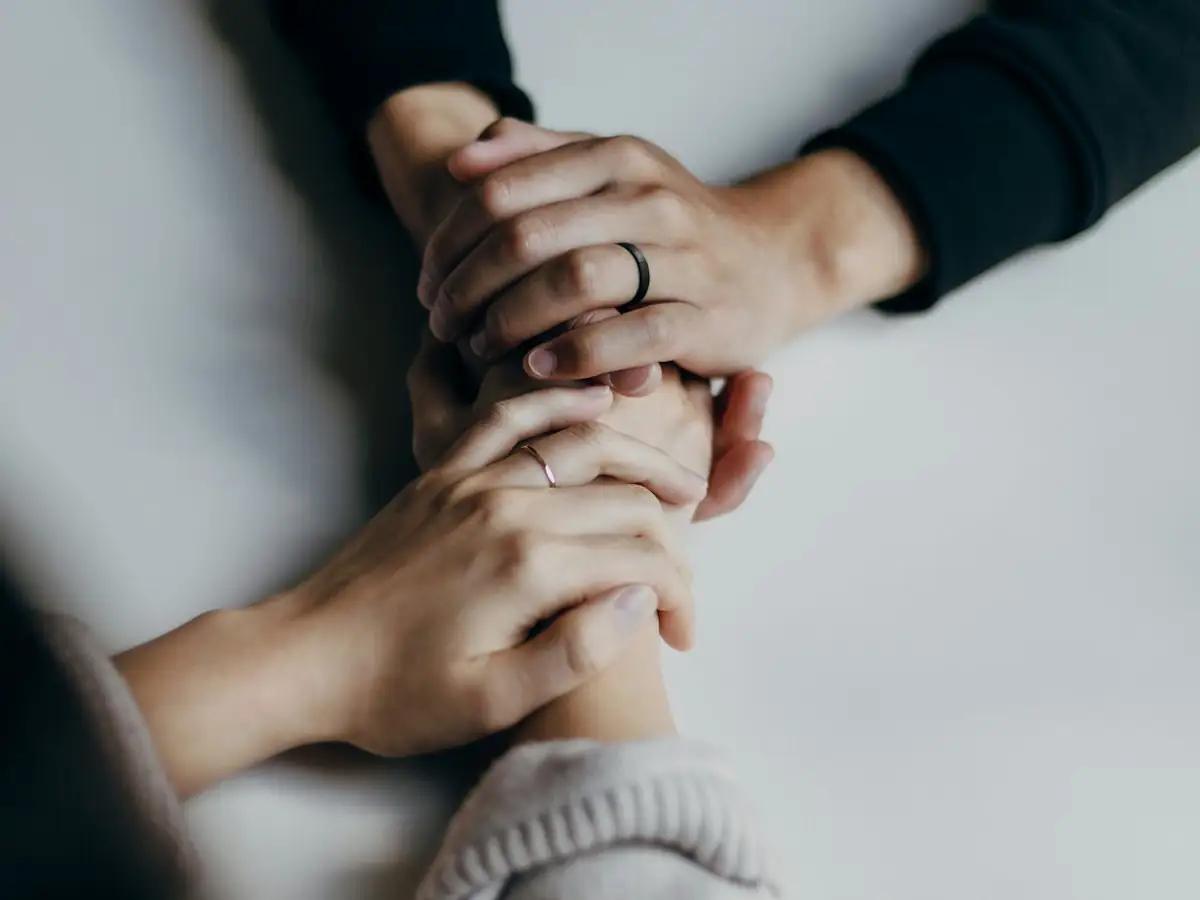Két ember egymás kezét fogja egy asztalnál